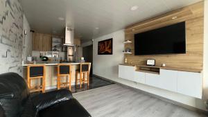 a living room with a television on a wall at Apartamento Simón Bolívar in Itagüí