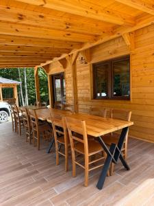 a wooden deck with a wooden table and chairs at Bujtina Lindi in Rrogam