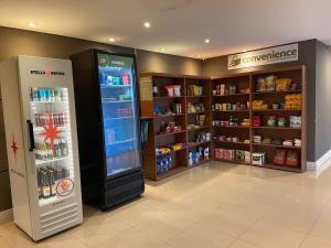 a store with a refrigerator and shelves of food at Studio Executivo c/ Garagem – Granja Viana | Cotia in Cotia