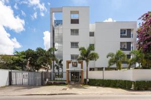 a white building with a gate in front of it at Studio Executivo c/ Garagem – Granja Viana | Cotia in Cotia