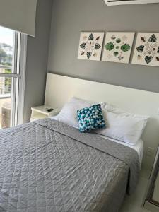 a bedroom with a bed with a blue pillow on it at Studio Executivo c/ Garagem – Granja Viana | Cotia in Cotia