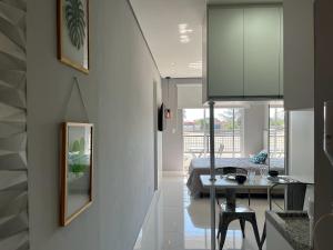 a kitchen and living room with a table and a bed at Studio Executivo c/ Garagem – Granja Viana | Cotia in Cotia