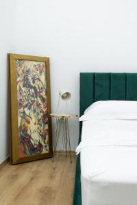 Un dormitorio con un cuadro al lado de una cama y una mesa. en Vila Seja, en Vlorë