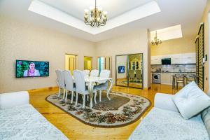 a dining room with a table and white chairs at Mardakan Garden Retreat in Mardakan