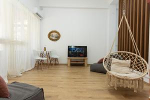 a living room with a swinging chair and a tv at Vila Seja in Vlorë