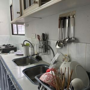 a kitchen sink with utensils on the wall at RapaatVip Homestay in Ipoh
