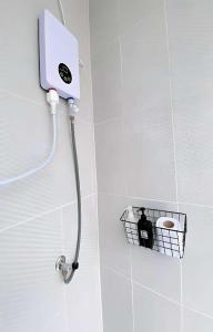 a shower in a bathroom with a toilet in a basket at X GO INN Hua Lamphong - MRT หัวลำโพง in Bangkok