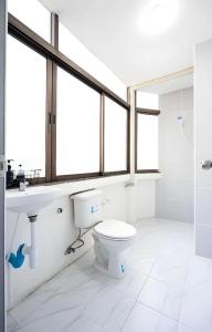 a bathroom with a toilet and a sink and windows at X GO INN Hua Lamphong - MRT หัวลำโพง in Bangkok +42 photos