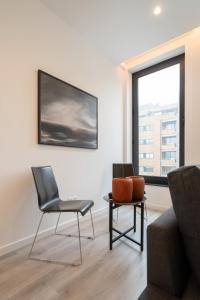 un soggiorno con due sedie e una finestra di Trendy Matosinhos Flat by HostWise a Matosinhos Altre 21 foto