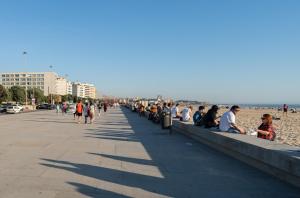un gruppo di persone seduti su un marciapiede vicino alla spiaggia di Trendy Matosinhos Flat by HostWise a Matosinhos