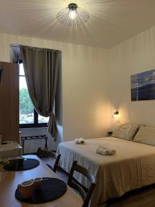 a bedroom with a bed and a table and a window at Trasimeno Vacanze in Passignano sul Trasimeno