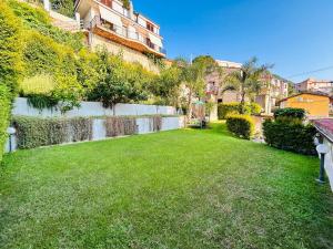 a yard with green grass and a wall at Casa Tramonto in Palmi