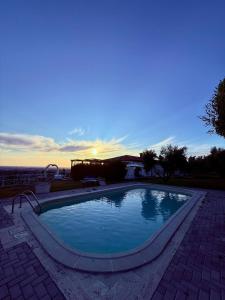 a swimming pool with a sunset in the background at La Vista Agriturismo Boutique in Ariccia