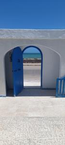 an archway with a blue door on the beach at La Brise de Djerba, Villa de Charme en bord de mer à Al Jazira in Mezraya