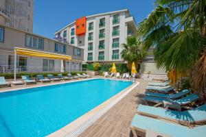 a swimming pool with lounge chairs and a hotel at Citrus Park Hotel in Antalya