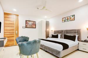 a bedroom with a bed and a blue chair at Townhouse The Grand Villa in New Delhi