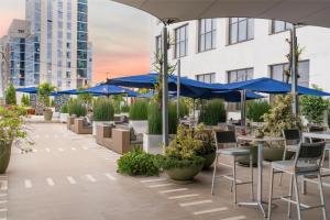 内罗毕Radisson Blu Hotel, Nairobi Upper Hill的一个带蓝伞和桌椅的庭院