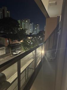 a view of a city at night from a balcony at Apartamento 1 dorm,com ar,frente faculdade in São Paulo +3 photos