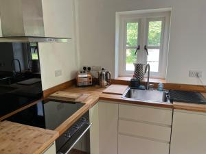 eine Küche mit Spüle und Herd in der Unterkunft Maes Y Grove Cottage in Llanddarog + 10 Fotos