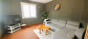 a living room with a couch and a tv at Le gite des Marchis 4 pers cour in Buzançais