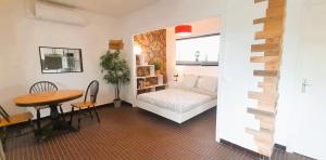 a room with a bed and a table and a bed and a desk at Le gite des Marchis 4 pers cour in Buzançais