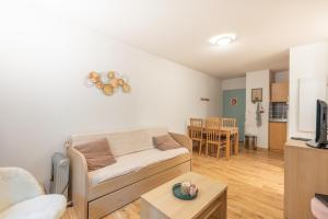 un soggiorno con un divano e un tavolo di Un Jardin Au Coeur De Luchon a Luchon