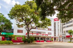 a white building with a tree in front of it at OYO Hotel Del Parque in Guadalajara