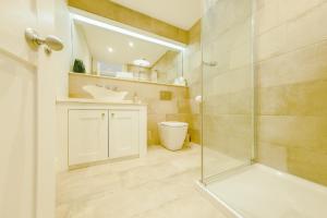 a bathroom with a shower and a toilet and a sink at Elegant 2-Bed Luxury Apartment - Prime Location in Bristol