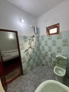een badkamer met een toilet en een douche bij Nimsara Holiday Resort in Anuradhapura