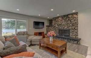 a living room with a stone fireplace and a table at Welk Manor Private Waterfront Retreat on the Spokane River in Post Falls