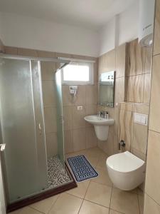 a bathroom with a shower and a toilet and a sink at Cameria in Durrës