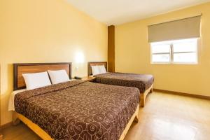 a hotel room with two beds and a window at Capital O Hotel Del Parque Guadalajara in Guadalajara +31 photos