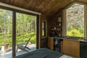 eine Küche mit großem Fenster in einer Hütte in der Unterkunft Tofte Trails in Tofte