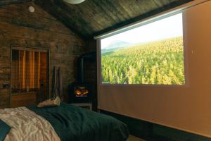 ein Schlafzimmer mit großem Fenster und Bergblick in der Unterkunft Tofte Trails in Tofte