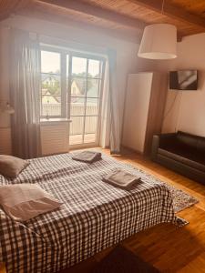 Un dormitorio con una cama y una ventana grande. en Saulės Namai, en Palanga 25 fotos más