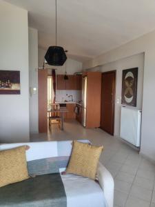 a living room with a couch and a kitchen at Διαμέρισμα "LENIA" μπροστά στην θάλασσα! in Kiaton