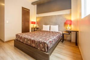 a hotel room with a bed and a desk at Capital O Hotel Del Parque Guadalajara in Guadalajara