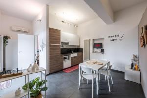 ボローニャにある*Love'n fly apartament * Airport- Ducatiの白いテーブルと椅子のあるキッチンとダイニングルーム