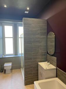 a bathroom with a sink and a toilet and a mirror at Townhead Jewel by Coorie Doon Stays in Paisley