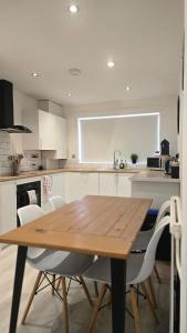 a kitchen with a wooden table and white cabinets at Grace's Place in Littleport in Littleport