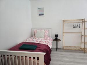 a white bedroom with a bed with a red blanket at Grace's Place in Littleport in Littleport
