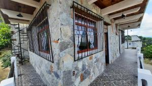 a stone wall with barred windows on a building at Casa de Campo Papalote in Cuetzalán del Progreso