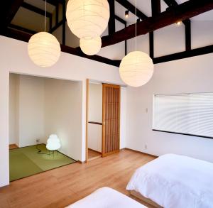 名古屋OneStay一宿 無料駐車場 駅徒歩2分 和モダン一軒家 小庭付き 静か お子様連れに優しい 名古屋駅近的有白色墙壁、木地板和灯光的卧室