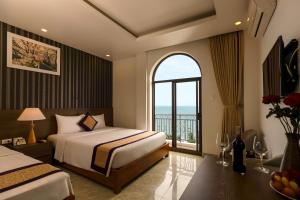 a bedroom with two beds and a window with a view at Luxor Boutique Hotel Phu Quoc in Phu Quoc +76 photos