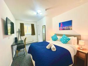 a bedroom with a blue bed and a desk at Henley Lodge in Henley in Arden