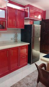 a kitchen with red cabinets and a black refrigerator at Fully Brand New Furnished Apartment in Sheikh Zayed