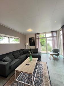 a living room with a couch and a coffee table at Lakeside Retreat at Veluwe in Nunspeet