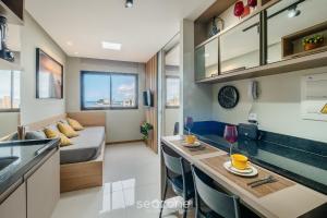 a small apartment with a bed and a kitchen with a counter at Apartamentos em Prédio c/ Piscina na Ondina - SSA - HOA in Salvador