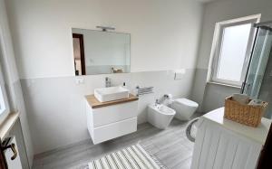 a white bathroom with a sink and a toilet at Dimora Tra Mare e Montagna in Lanciano