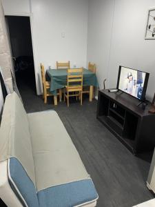 a living room with a couch and a table and a tv at Guazuvira nuevo, sandú coast in Guazuvira